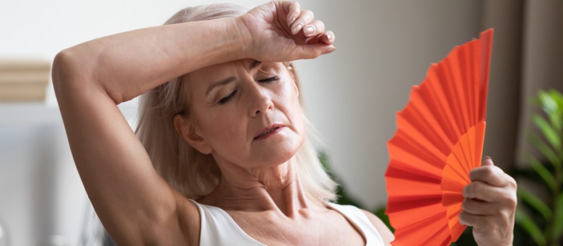 Tired,Overheated,Middle,Aged,Lady,Wave,Fan,Suffer,From,Menopause