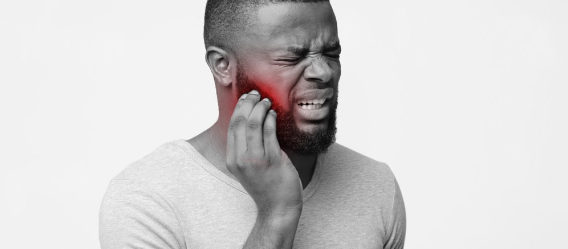 Irritated,Black,Man,Suffering,From,Tooth,Pain,,Holding,His,Inflamed