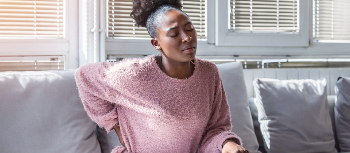 Young,Black,Woman,Suffering,From,Backache,At,Home.,Portrait,Of